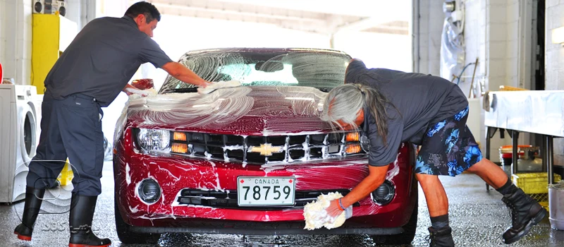 تصویر دو نفر در حال شستشو ماشین به روش سنتی در کانادا